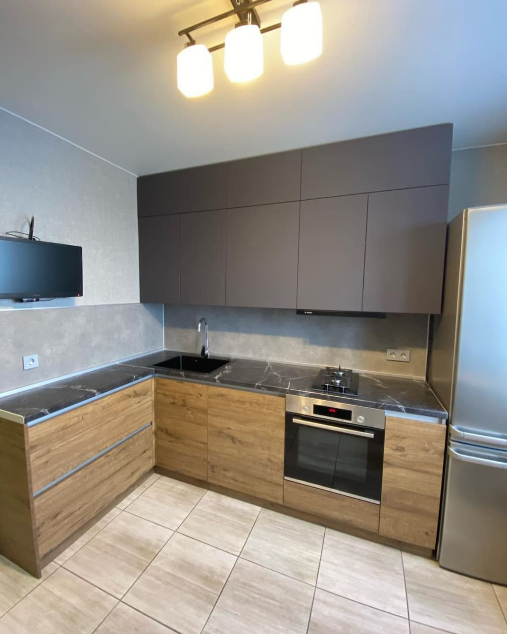 Угловая кухня в коричневом цвете с матовыми и древесными фасадами