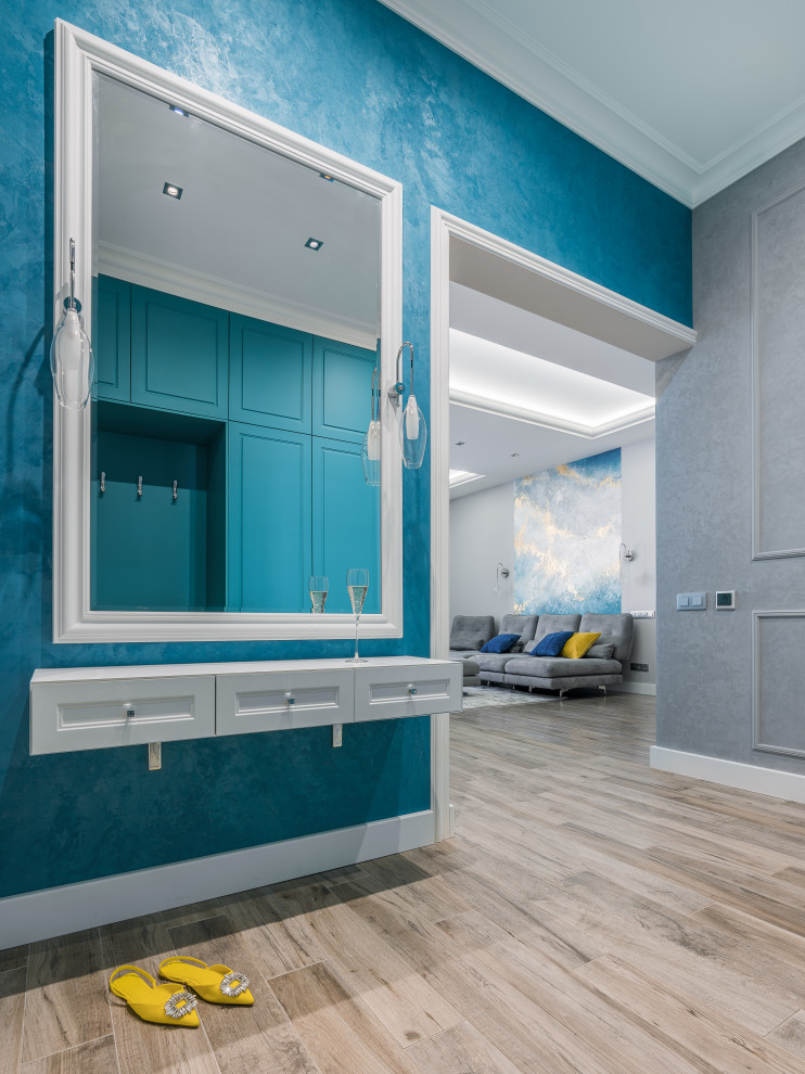 Aménagement d'une porte d'entrée de taille moyenne avec un mur bleu, un sol en carrelage de porcelaine, une porte simple, une porte blanche et un sol gris.
