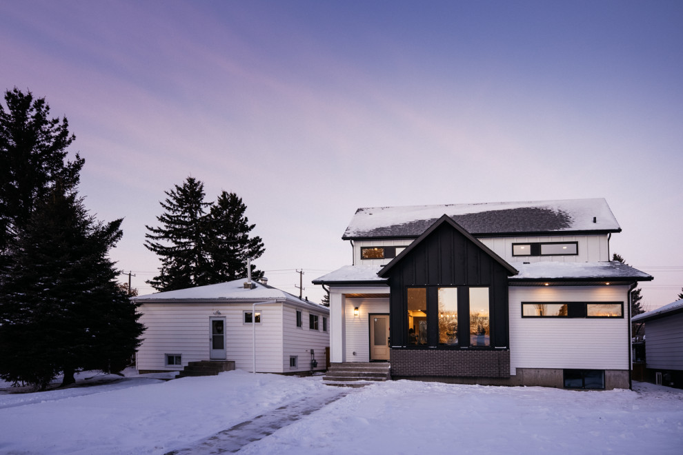 Mittelgroßes, Zweistöckiges Country Einfamilienhaus mit Metallfassade, schwarzer Fassadenfarbe, Satteldach, Schindeldach, grauem Dach und Wandpaneelen in Edmonton
