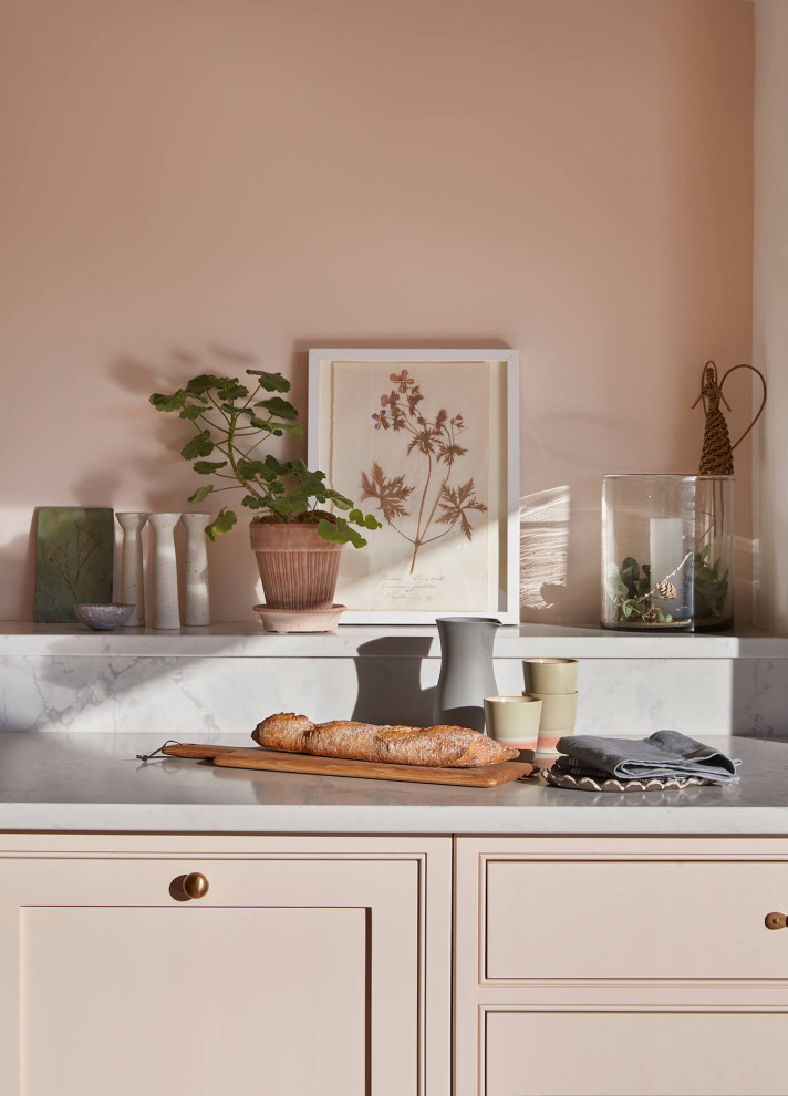 Inspiration for a large country grey and pink single-wall open plan kitchen in London with a belfast sink, shaker cabinets, pink cabinets, quartz worktops, pink splashback, black appliances, ceramic flooring, an island, multi-coloured floors, grey worktops and a vaulted ceiling.
