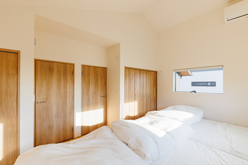 Cette photo montre une chambre d'enfant de 4 à 10 ans scandinave de taille moyenne avec un mur blanc, un sol en bois brun, un sol marron, un plafond voûté et du papier peint.