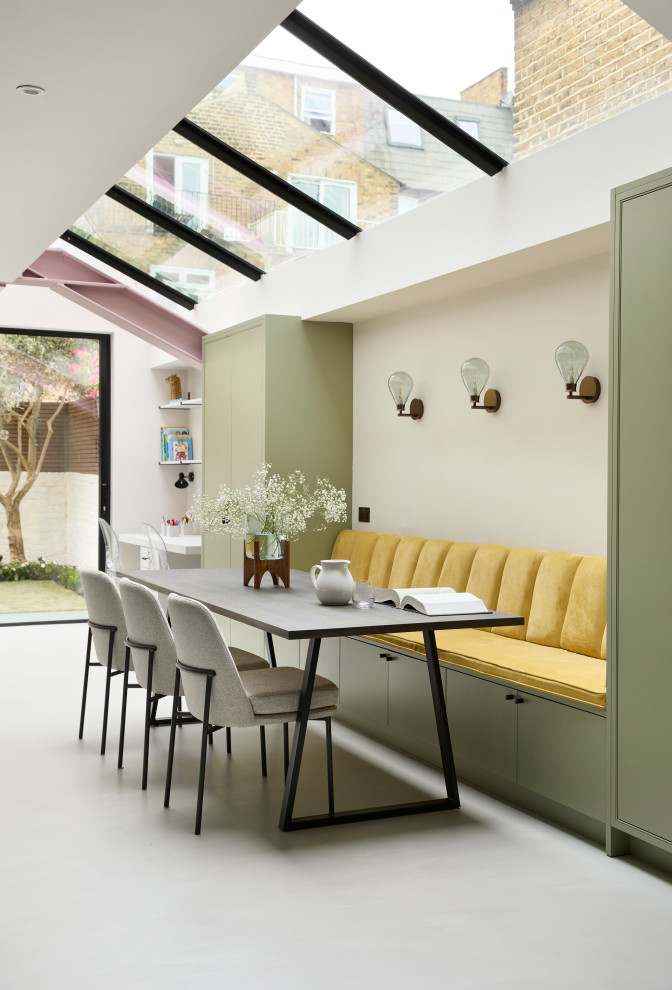 This is an example of a large contemporary open plan dining room in London with grey floors.