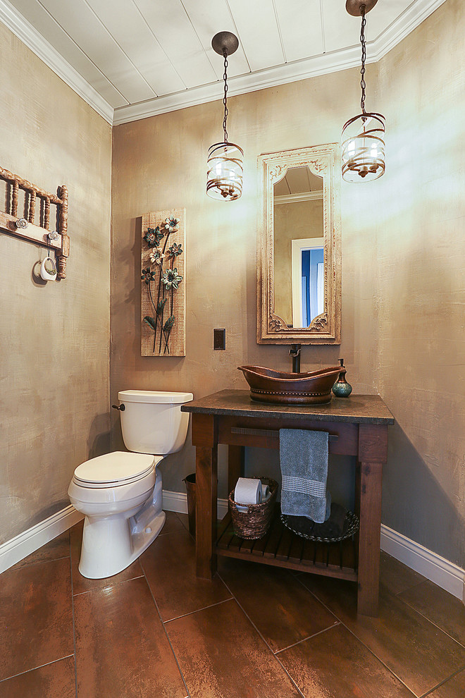 Photo of a country bathroom in Other with open cabinets, dark wood cabinets, a two-piece toilet, brown tile, porcelain tile, grey walls, ceramic floors, a vessel sink and granite benchtops.