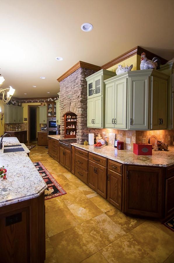 Eat-in kitchen - large rustic u-shaped porcelain tile and beige floor eat-in kitchen idea with an undermount sink, raised-panel cabinets, green cabinets, granite countertops, beige backsplash, porcelain backsplash, stainless steel appliances, an island and multicolored countertops