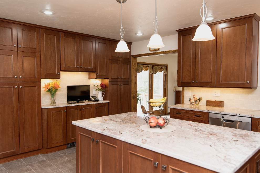 Design ideas for a large traditional l-shaped eat-in kitchen in Baltimore with an undermount sink, shaker cabinets, medium wood cabinets, granite benchtops, beige splashback, ceramic splashback, stainless steel appliances, vinyl floors, with island, beige floor and white benchtop.