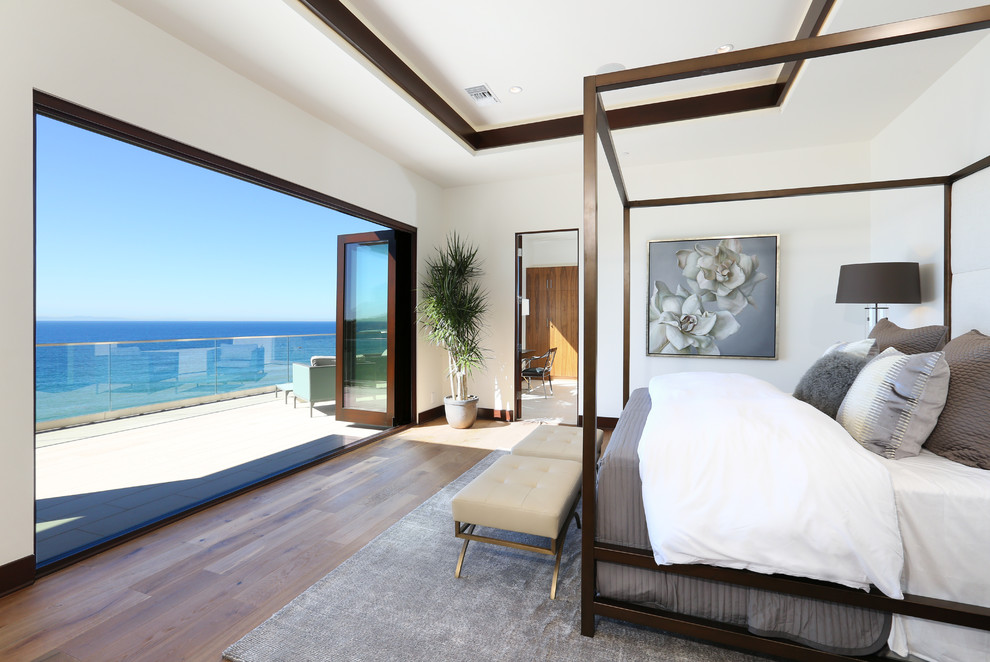 Inspiration for a large contemporary master bedroom in Orange County with white walls and medium hardwood floors.