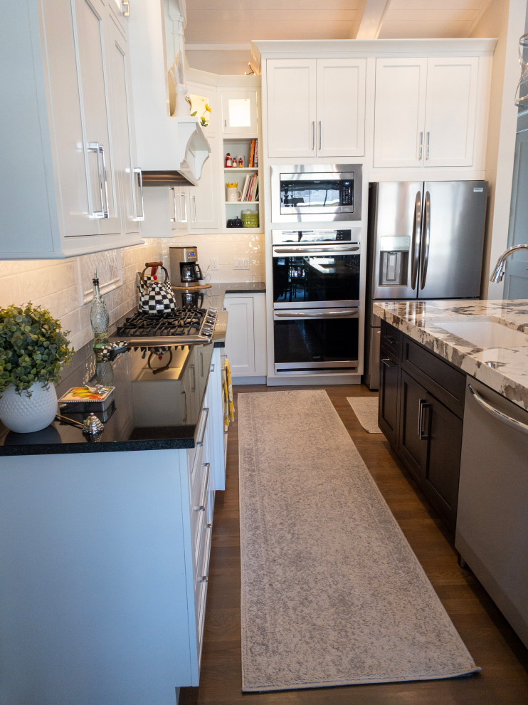 Inspiration for a large transitional l-shaped medium tone wood floor, gray floor and shiplap ceiling eat-in kitchen remodel with an undermount sink, flat-panel cabinets, white cabinets, granite countertops, yellow backsplash, subway tile backsplash, stainless steel appliances, an island and white countertops