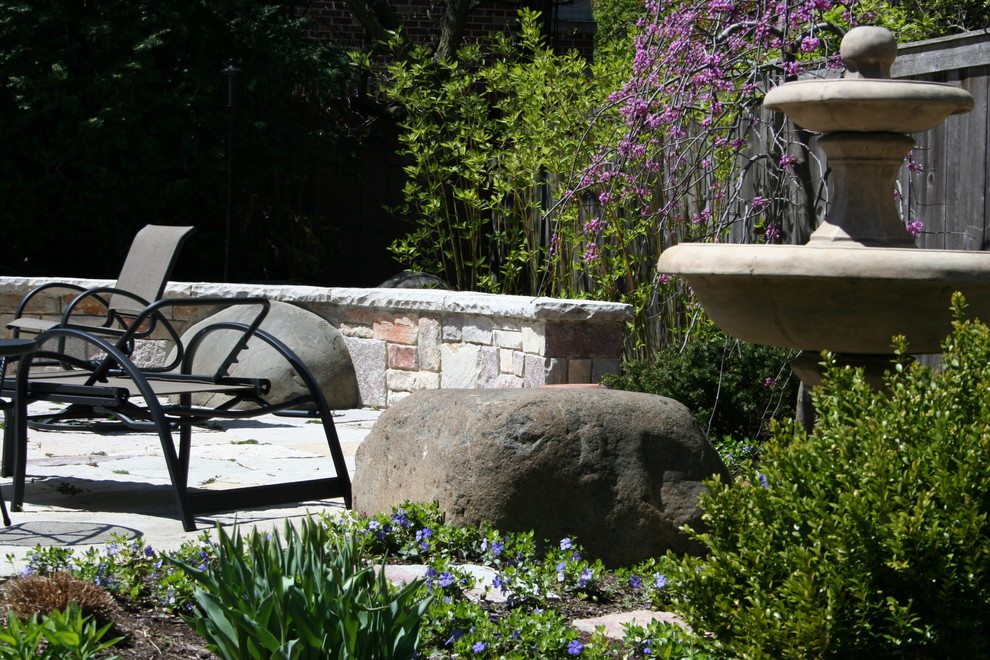 Inspiration for a mid-sized traditional backyard patio in Chicago with natural stone pavers.