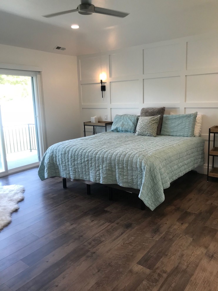Photo of a large country master bedroom in Salt Lake City with white walls, dark hardwood floors, no fireplace and brown floor.