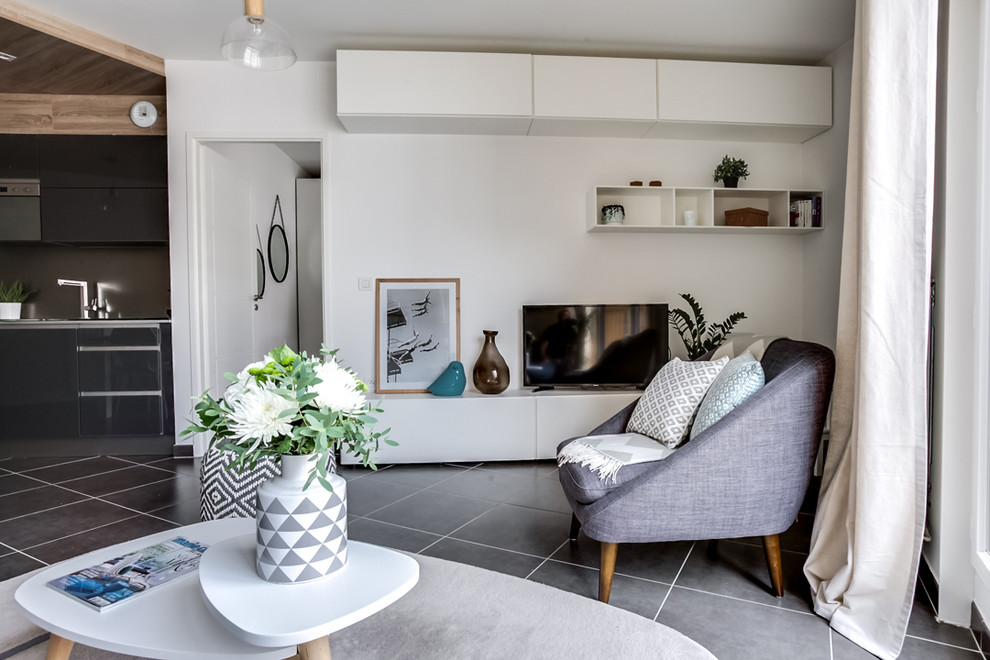 Small scandinavian open concept living room in Paris with white walls, a freestanding tv, no fireplace, grey floor and a library.
