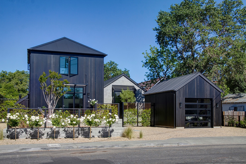 Large country two-storey black exterior in San Francisco with wood siding.