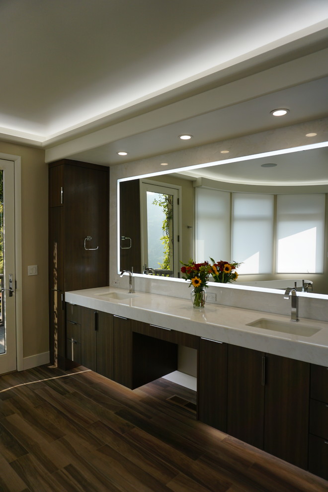 Inspiration for a large contemporary master bathroom in San Francisco with flat-panel cabinets, medium wood cabinets, a freestanding tub, a double shower, a one-piece toilet, white tile, stone slab, beige walls, porcelain floors, an undermount sink, marble benchtops, brown floor, a hinged shower door and white benchtops.