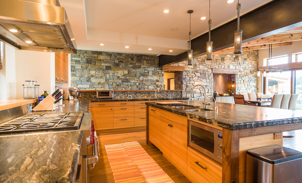 Photo of a country l-shaped open plan kitchen in Seattle with a double-bowl sink, flat-panel cabinets, light wood cabinets, soapstone benchtops, multi-coloured splashback, mosaic tile splashback, stainless steel appliances, light hardwood floors, with island and beige floor.