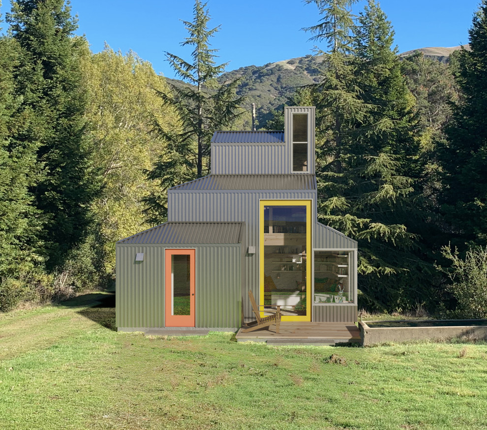 На фото: маленький, одноэтажный мини дом в стиле шебби-шик с облицовкой из металла и металлической крышей для на участке и в саду, охотников с