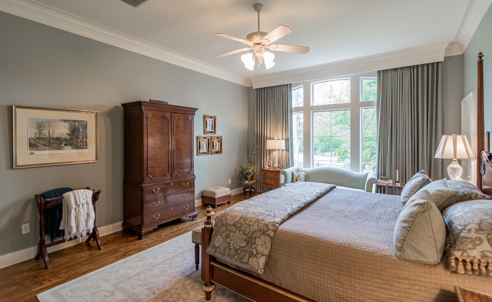 Large elegant master medium tone wood floor bedroom photo in New Orleans with gray walls and no fireplace