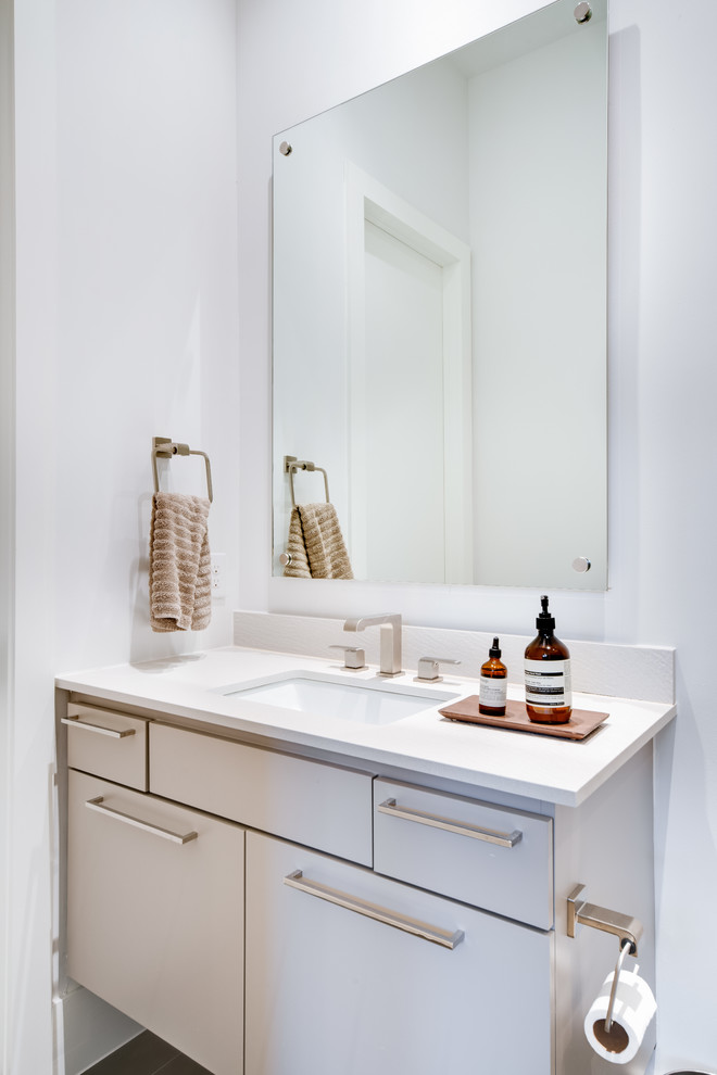 This is an example of a mid-sized contemporary kids bathroom in Dallas with flat-panel cabinets, grey cabinets, a freestanding tub, a double shower, a one-piece toilet, gray tile, porcelain tile, beige walls, porcelain floors, an undermount sink, engineered quartz benchtops, grey floor, a hinged shower door and white benchtops.