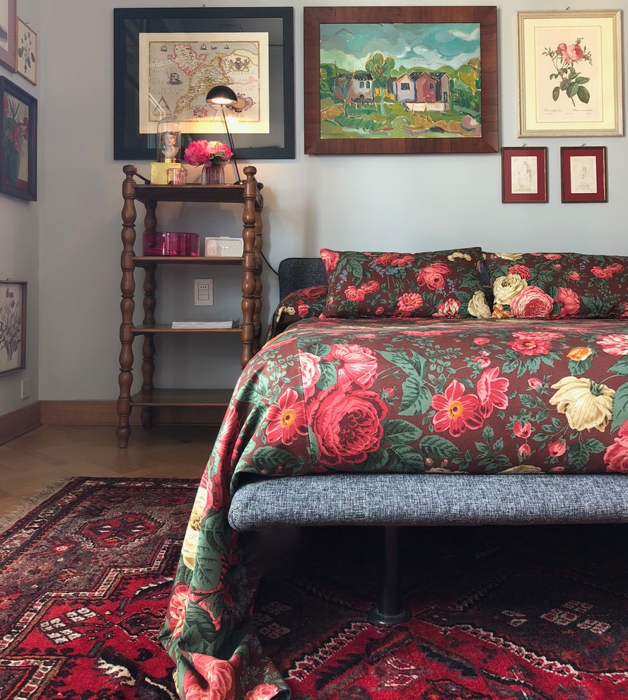 Small eclectic master bedroom in Venice with grey walls, brown floor and medium hardwood floors.