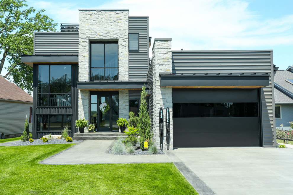 Aménagement d'une façade de maison métallique et marron moderne à deux étages et plus avec un toit en métal et un toit noir.