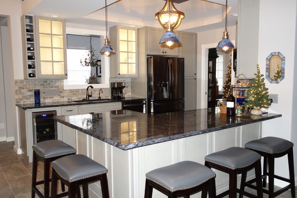 Open concept kitchen - mid-sized transitional ceramic tile open concept kitchen idea in Miami with an undermount sink, flat-panel cabinets, gray cabinets, granite countertops, gray backsplash, stone tile backsplash and stainless steel appliances