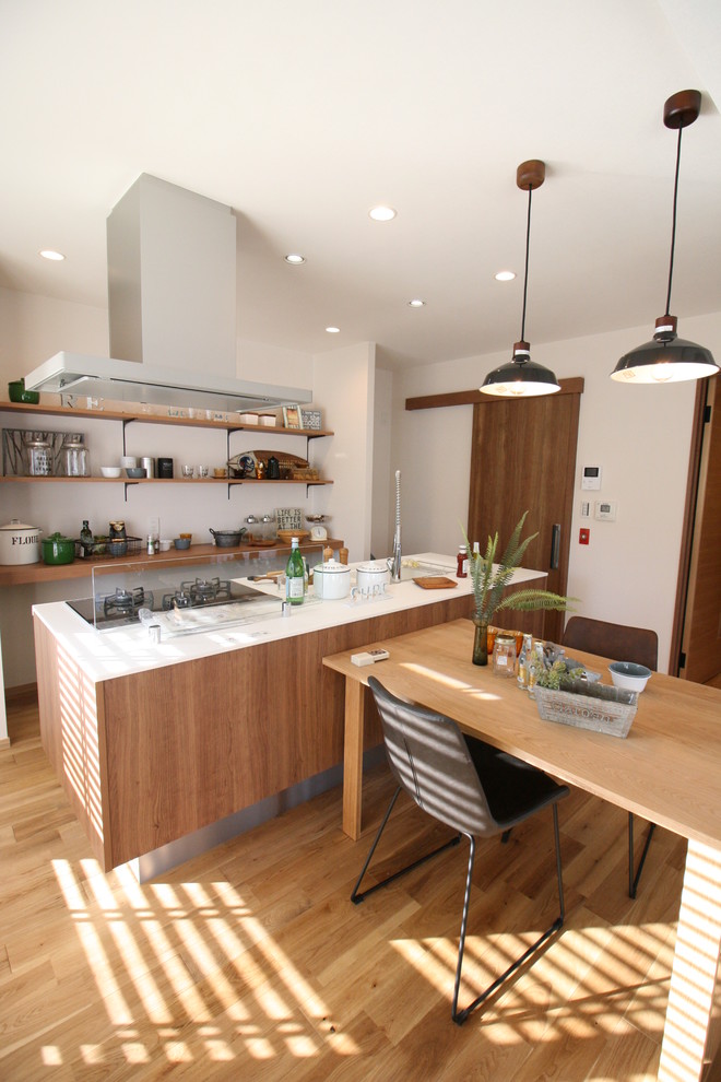 Photo of a mid-sized country single-wall kitchen in Other with an integrated sink, medium wood cabinets, medium hardwood floors, with island and brown floor.