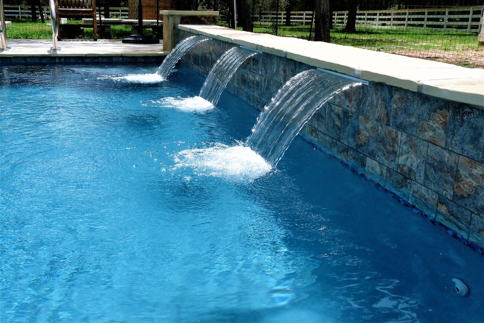 Design ideas for a large modern side yard rectangular pool in Houston with a hot tub and concrete slab.