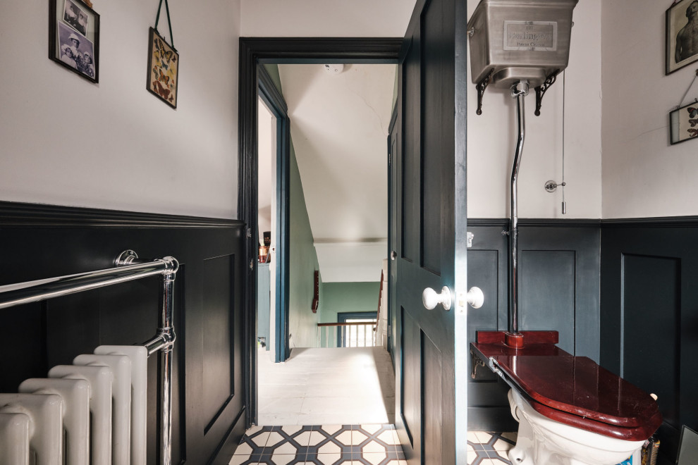 Inspiration for a mid-sized eclectic kids bathroom in London with a claw-foot tub, a shower/bathtub combo, a two-piece toilet, white walls, ceramic floors, a wall-mount sink, blue floor, a single vanity, a floating vanity, vaulted and panelled walls.