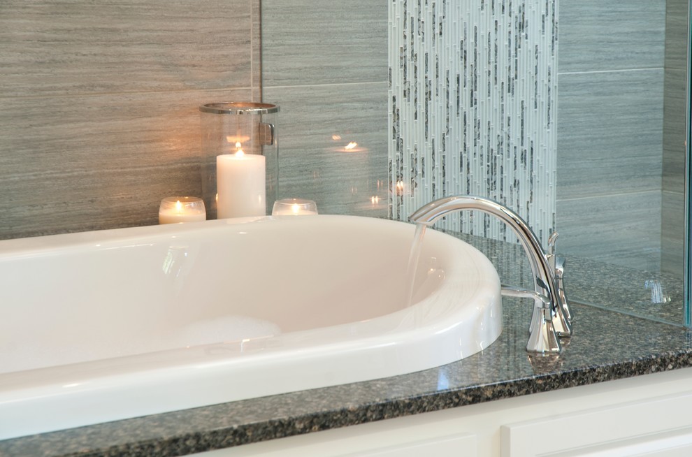 Inspiration for a large contemporary master bathroom in Vancouver with an undermount sink, raised-panel cabinets, white cabinets, engineered quartz benchtops, a drop-in tub, a shower/bathtub combo, a two-piece toilet, gray tile, porcelain tile, grey walls and porcelain floors.