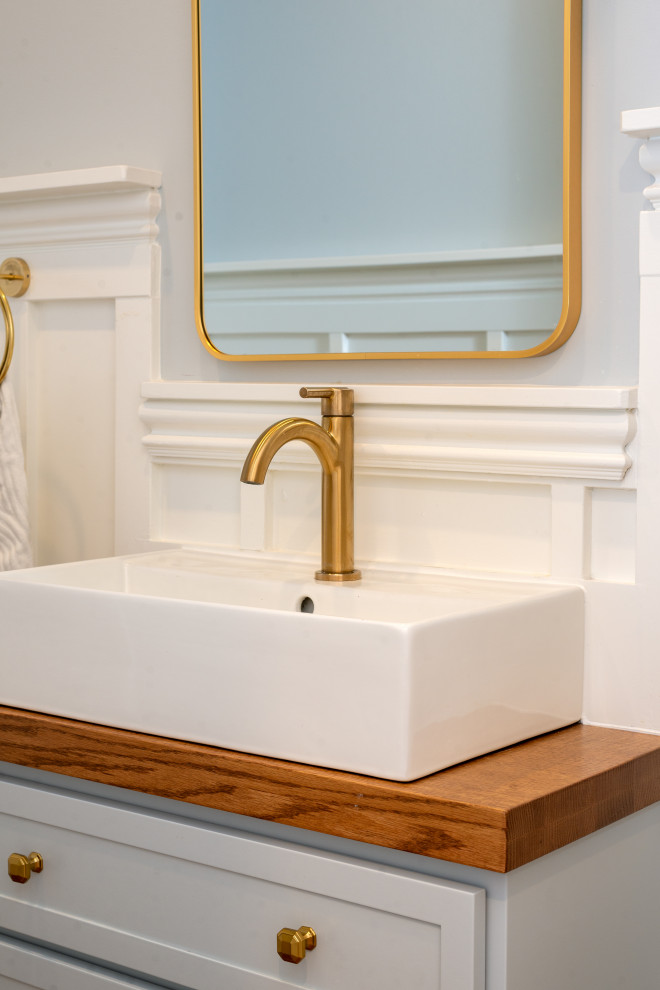 Powder room - medium tone wood floor powder room idea with blue cabinets, blue walls, wood countertops and a built-in vanity