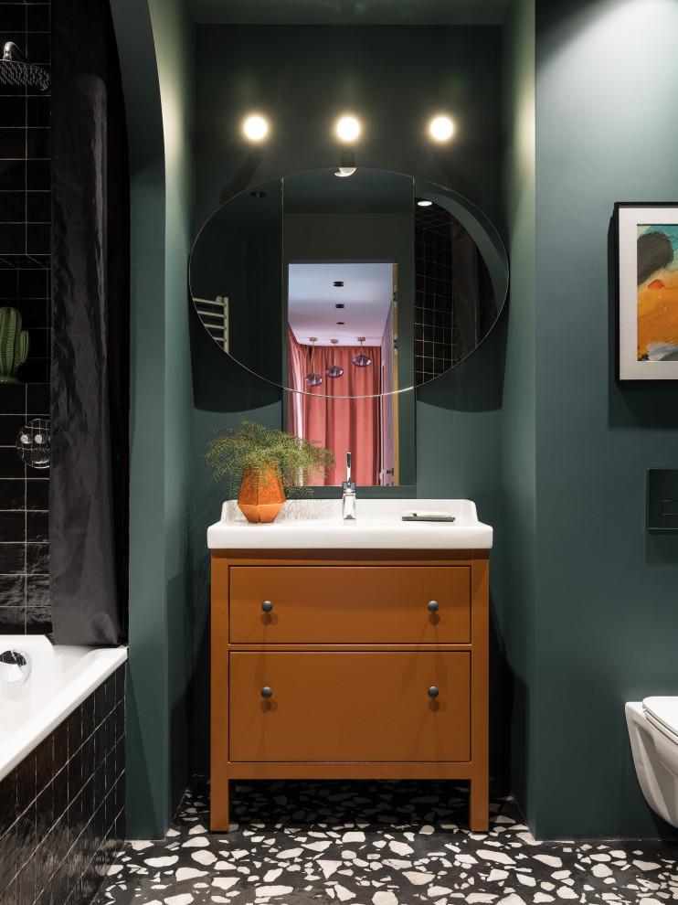 Идея дизайна: ванная комната в стиле неоклассика (современная классика) с плоскими фасадами, оранжевыми фасадами, ванной в нише, душем над ванной, черной плиткой, зелеными стенами, монолитной раковиной, разноцветным полом, шторкой для ванной, белой столешницей, тумбой под одну раковину и напольной тумбой