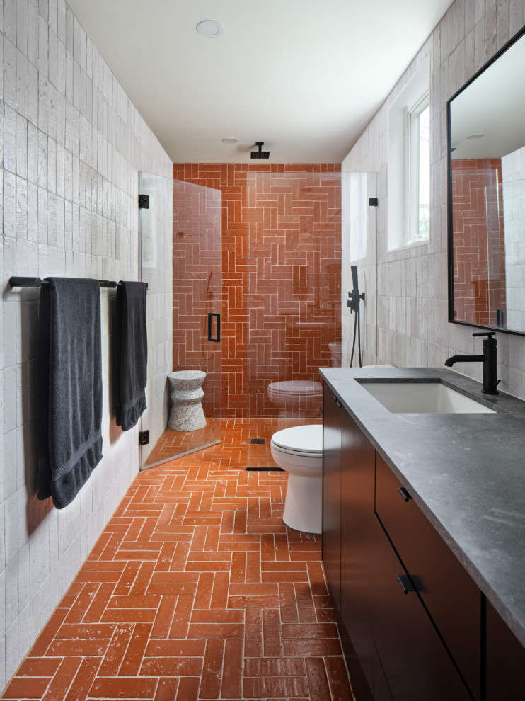 Cette photo montre une salle de bain moderne avec un sol en brique, un plan de toilette en béton, un sol rouge, un plan de toilette gris, meuble double vasque et meuble-lavabo encastré.