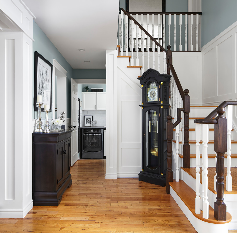 Photo of a mid-sized transitional hallway in Toronto with blue walls, light hardwood floors and brown floor.