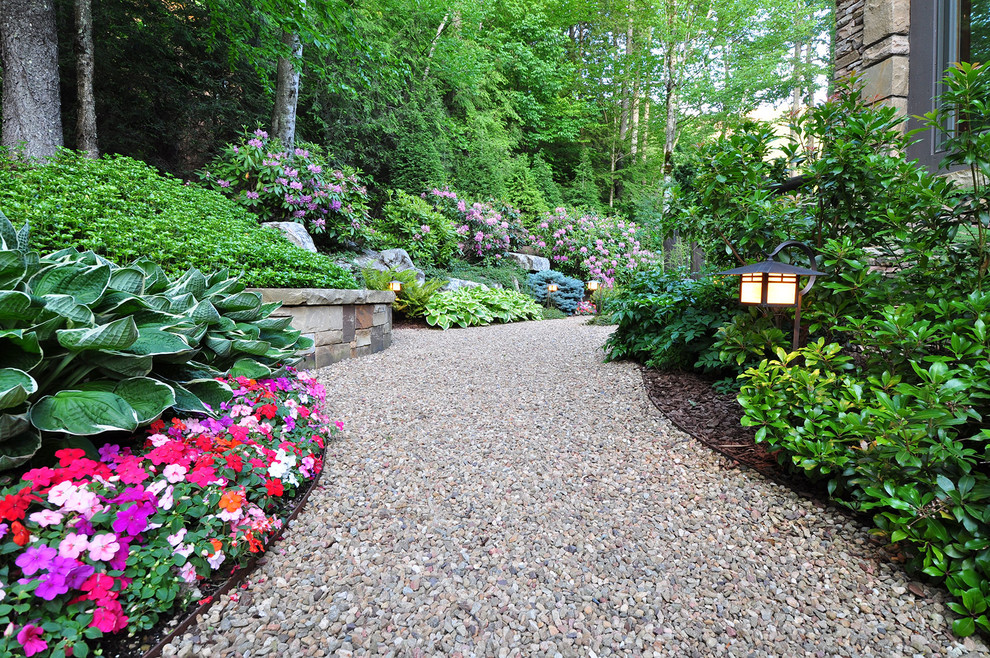 This is an example of a large traditional front yard partial sun formal garden in Other with a garden path and natural stone pavers.