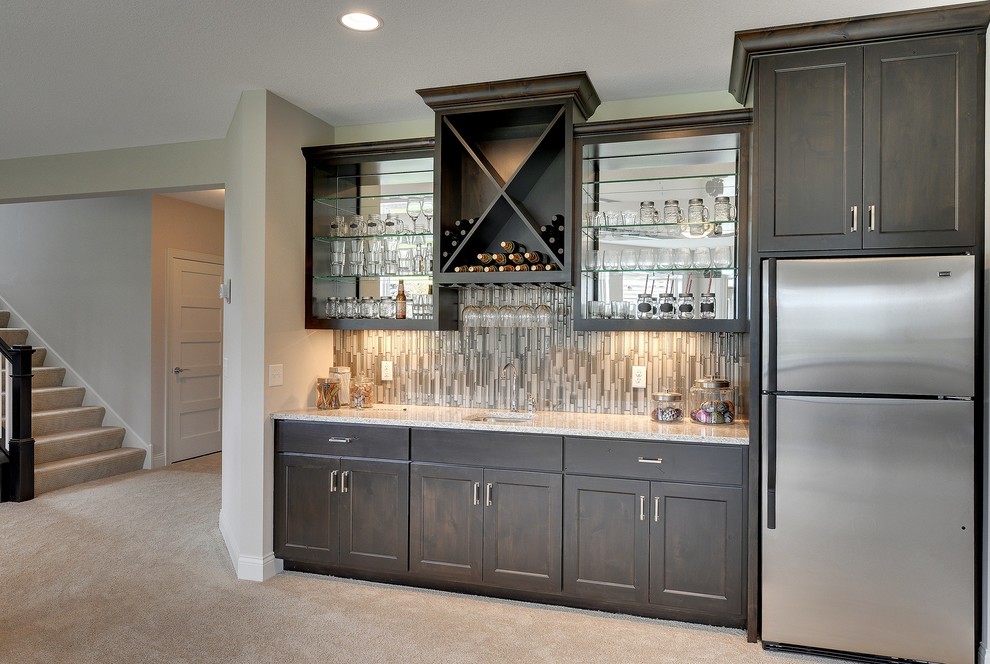 Large transitional single-wall wet bar in Minneapolis with an undermount sink, recessed-panel cabinets, brown cabinets, grey splashback, mosaic tile splashback and carpet.