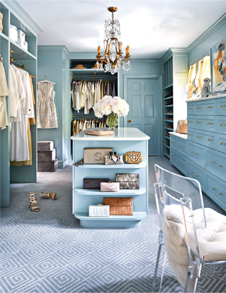 Traditional women's walk-in wardrobe in New York with recessed-panel cabinets, blue cabinets, carpet and blue floor.