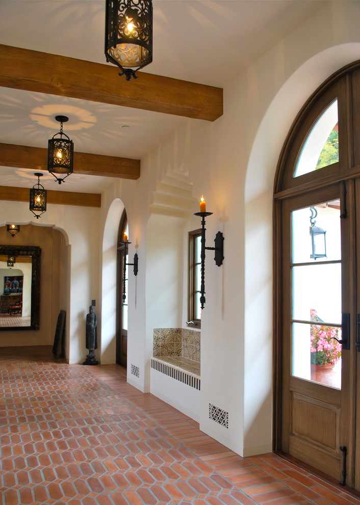 Large mediterranean hallway in Santa Barbara with white walls and terra-cotta floors.