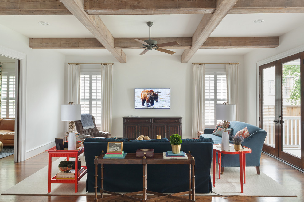 Design ideas for an expansive contemporary formal open concept living room in Houston with white walls, medium hardwood floors, a wall-mounted tv, no fireplace, brown floor and exposed beam.