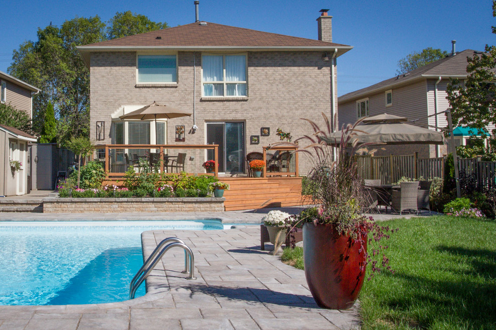 Inspiration for a mid-sized contemporary backyard rectangular lap pool in Toronto with brick pavers and with a pool.