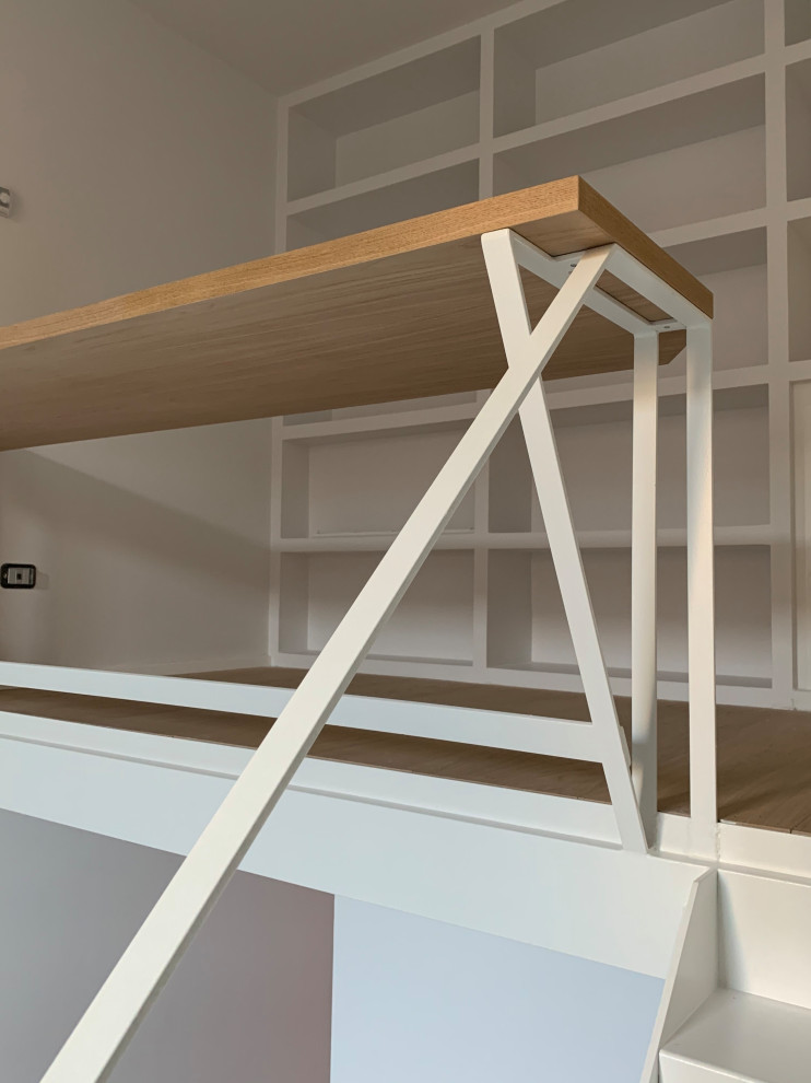 Immagine di un piccolo atelier minimal con pareti bianche, pavimento in legno massello medio e scrivania incassata