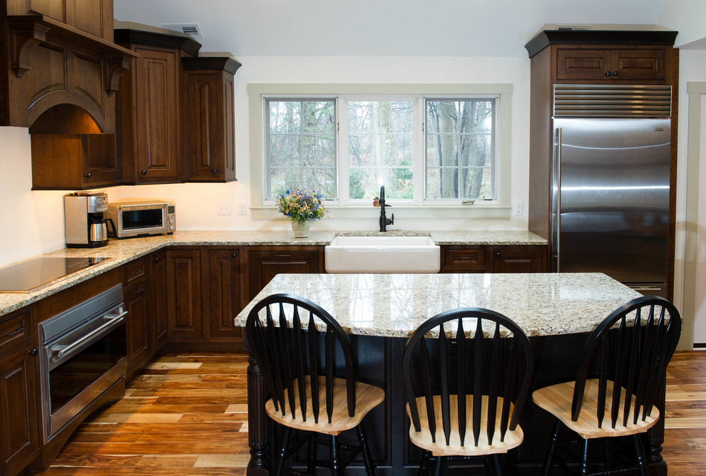 Traditional l-shaped kitchen in Philadelphia with raised-panel cabinets, stainless steel appliances and a farmhouse sink.