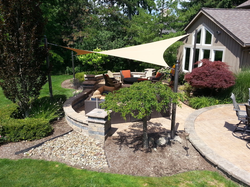 Photo of a mid-sized traditional backyard patio in Cleveland with concrete pavers and an awning.