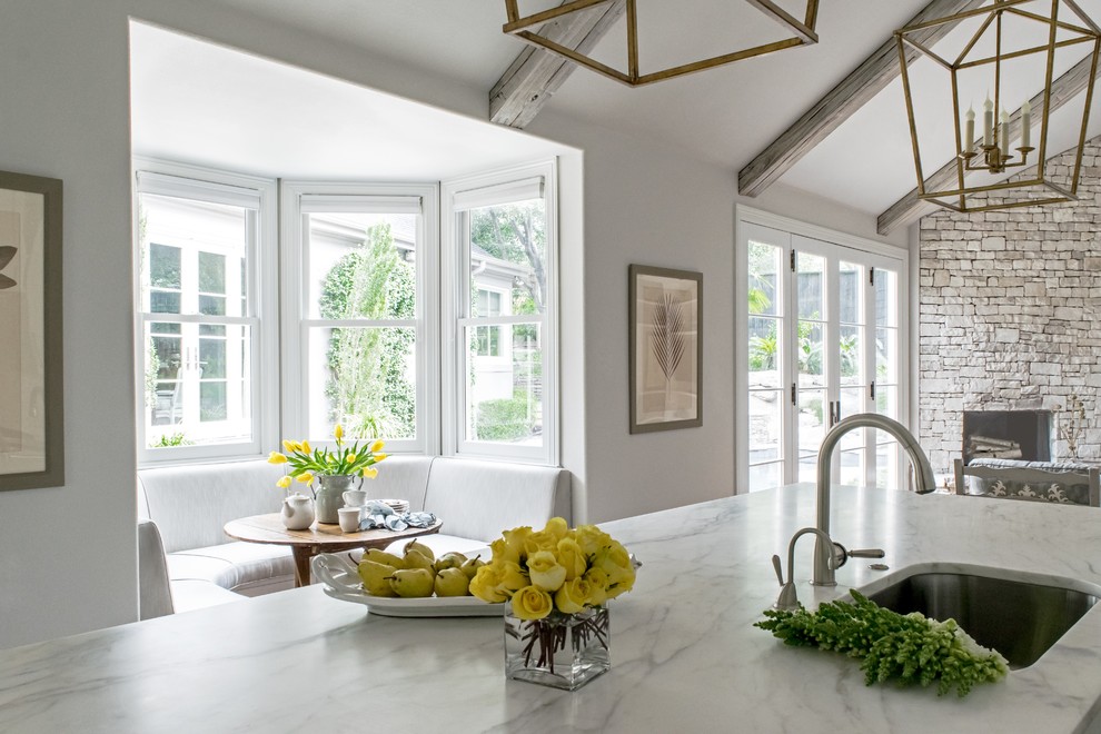 Open concept kitchen - transitional galley medium tone wood floor open concept kitchen idea in Austin with a single-bowl sink, recessed-panel cabinets, white cabinets, marble countertops, white backsplash, stone slab backsplash, paneled appliances and an island