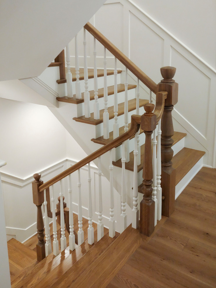 На фото: п-образная лестница среднего размера в классическом стиле с деревянными ступенями, крашенными деревянными подступенками, деревянными перилами и панелями на стенах