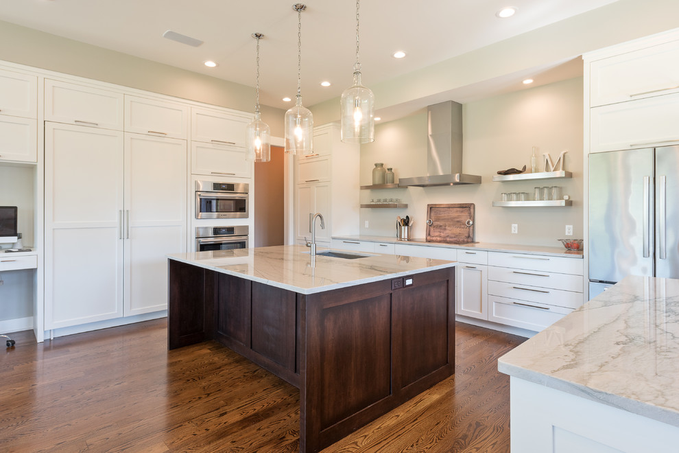 Mid-sized transitional u-shaped dark wood floor and brown floor open concept kitchen photo with an undermount sink, shaker cabinets, white cabinets, marble countertops, stainless steel appliances and an island