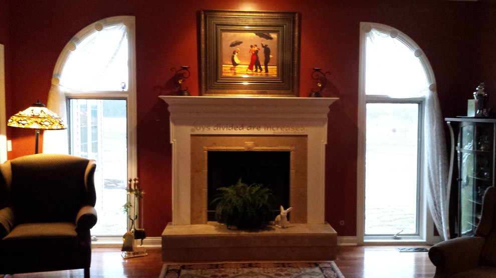 Inspiration for a mid-sized traditional enclosed living room in Other with red walls, dark hardwood floors, a standard fireplace, a stone fireplace surround and brown floor.