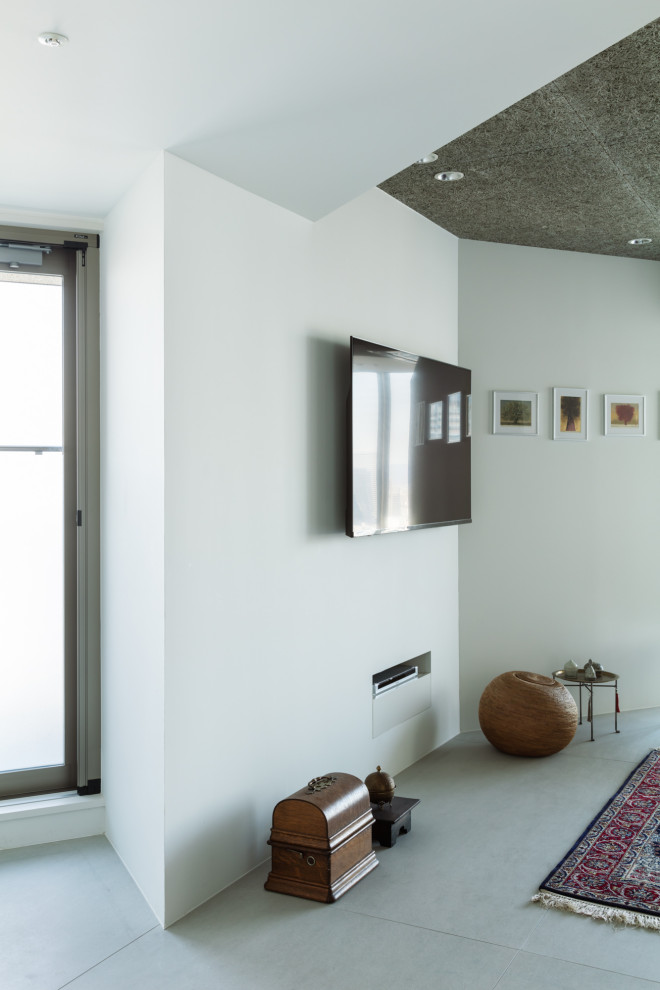 Modelo de salón abierto, gris y gris y negro minimalista de tamaño medio sin chimenea con paredes blancas, suelo de cemento, televisor colgado en la pared, suelo gris, madera y machihembrado