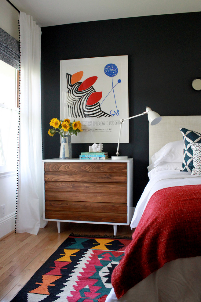 This is an example of a small contemporary teen room for girls in Los Angeles with light hardwood floors and black walls.
