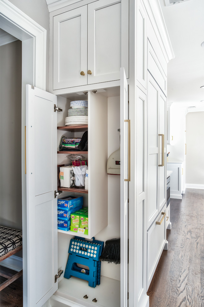 Kitchen - transitional dark wood floor kitchen idea in New York with a farmhouse sink, white cabinets, quartz countertops and paneled appliances