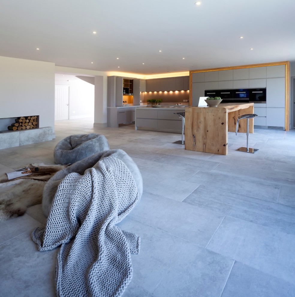 Expansive contemporary open plan kitchen in Cheshire with a double-bowl sink, flat-panel cabinets, grey cabinets, quartzite benchtops, grey splashback, glass sheet splashback, stainless steel appliances, porcelain floors and multiple islands.