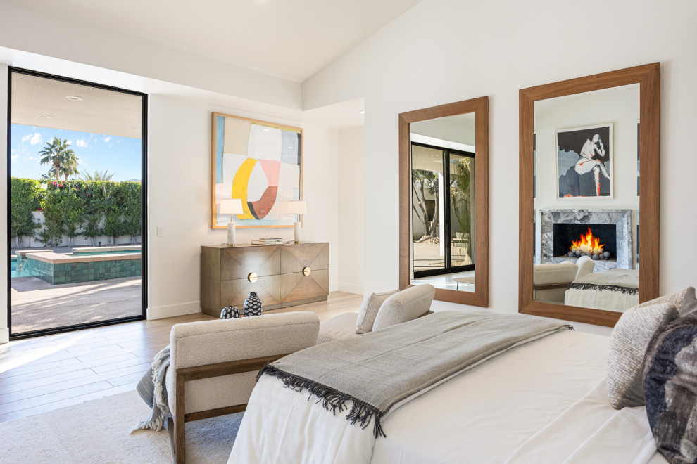 Inspiration for a large transitional master porcelain tile, beige floor and vaulted ceiling bedroom remodel with white walls, a standard fireplace and a stone fireplace