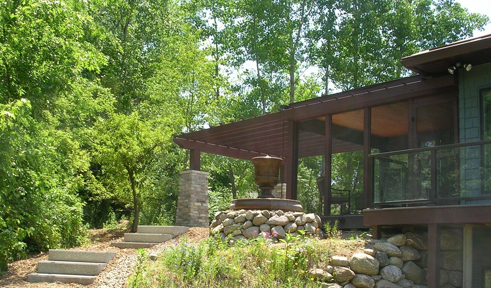 Example of a small mountain style backyard concrete patio design with a pergola